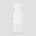 Front view of a white tiered lace maxi dress by self-portrait. The dress features a sheer lace high neck with short sleeves with an opaque fitted bust. The bottom of the dress is divided into 3 tiers of lace overlapping each other.